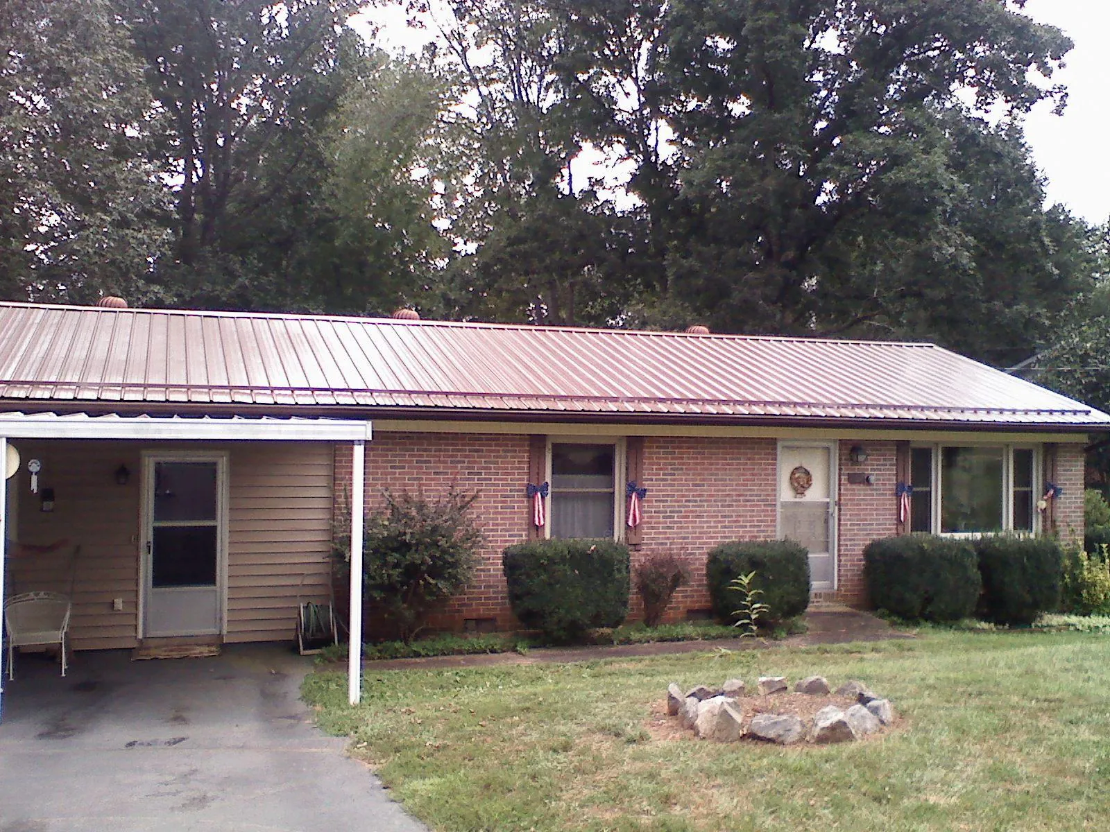 Bronze metal roof and carport on a brick ranch home — Roof Repair work by our crew in Buckley